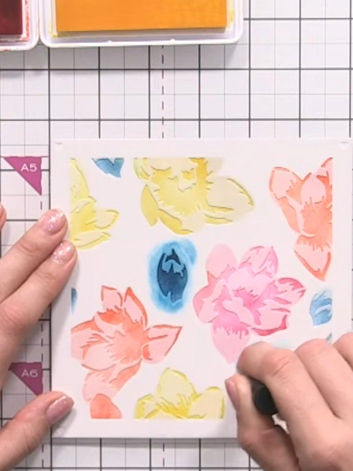Step 3: Remove the first stencil and position the second stencil over the coloured area. Apply blue ink to the leaves 