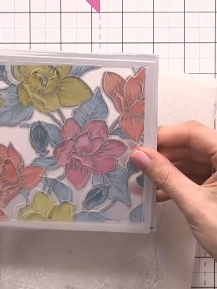 Step 7: Place the die-cut floral design into the embossing folder with the chamfered edge facing up, then run through 