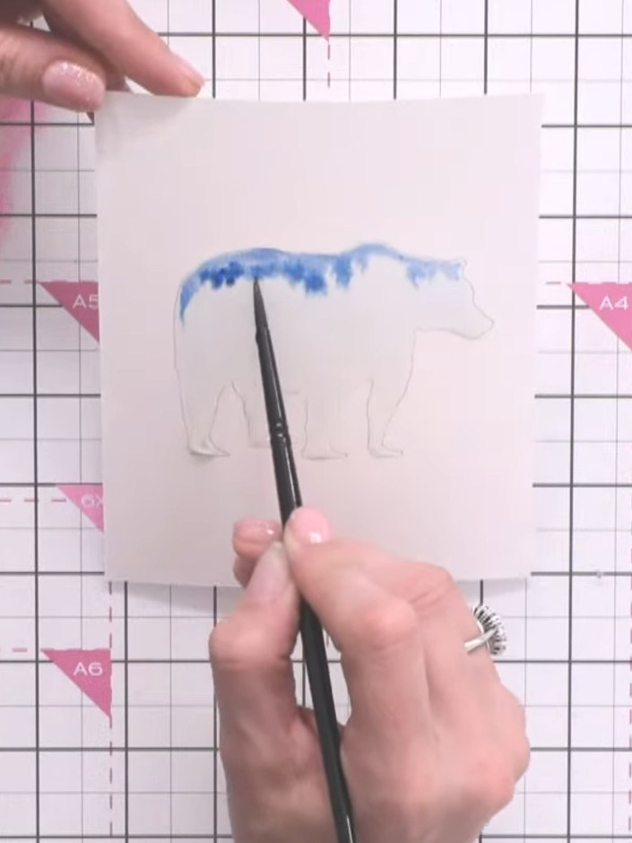Step 6: Use a dry brush to lift excess water and puddles from the blue watercolour area. Dab the brush bristles on tis