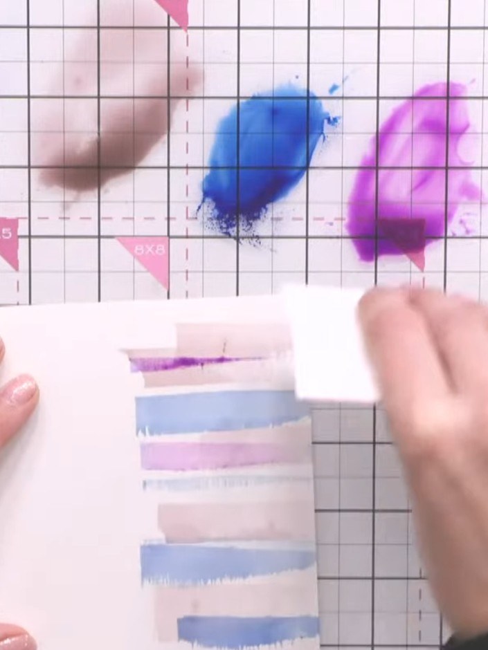 Step 6: Zieh die Farbe mit deinem Pinsel von den Gebäudelinien nach unten, damit Spiegelungen im Wasser darunter entstehen. Pull