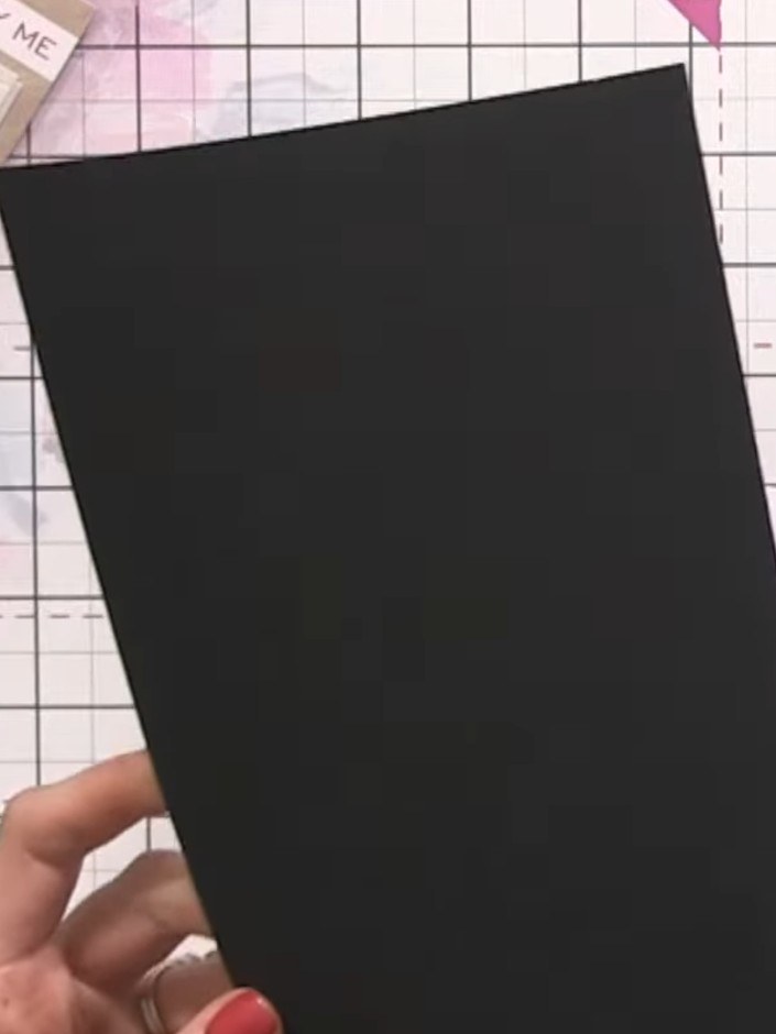 Step 1: Cut a black cardstock layer and mount it onto your white card base using adhesive. Position the black layer to