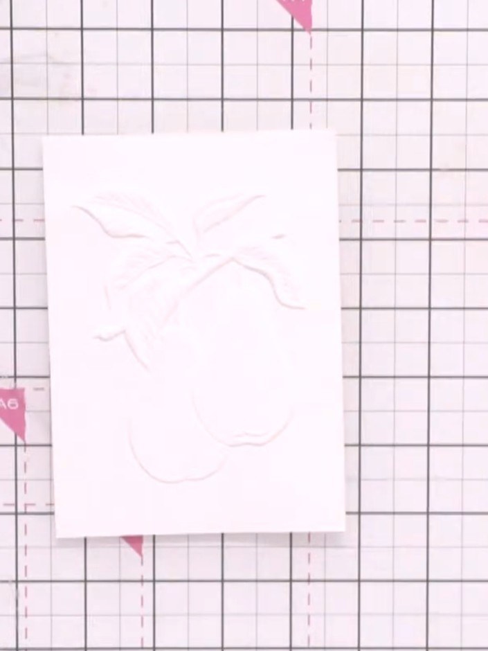 Step 3: Drop watercolour paint onto the wet embossed pear image in multiple colours including pink, orange and yellow.