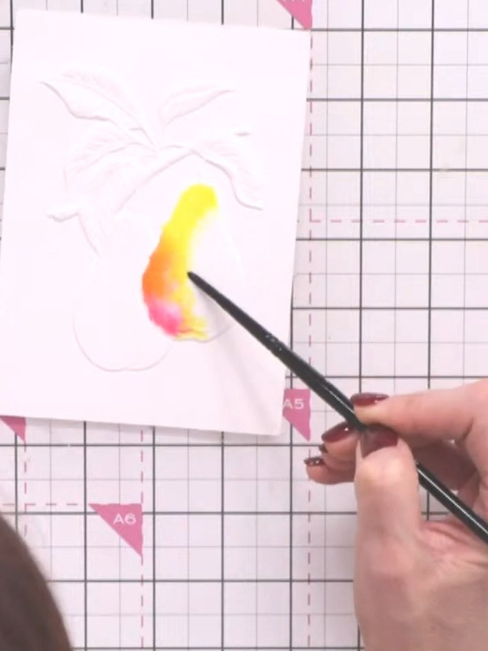 Step 5: Using a wet paintbrush, add water to the edge of the pear shape. Paint the pear with yellow, orange and pink w