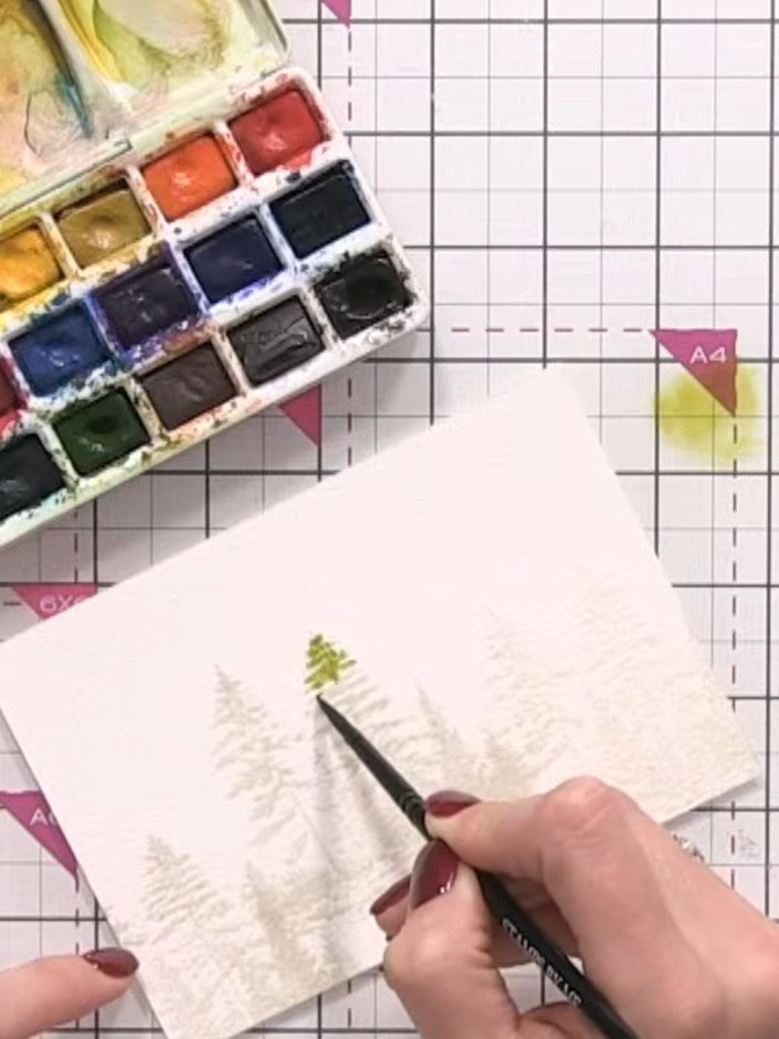 Step 5: Drop green watercolour paint onto the wet area of the tree shape, allowing it to flow and blend naturally with