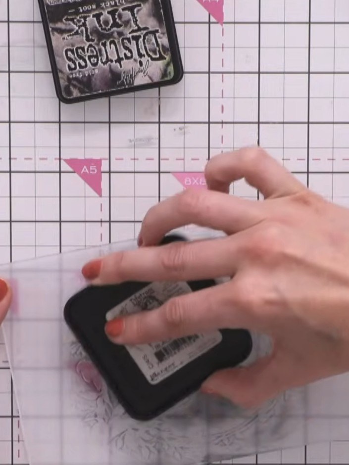 Step 11: Ink up the entire embossing folder with black ink using an ink pad. Run the card through the die-cutting machi