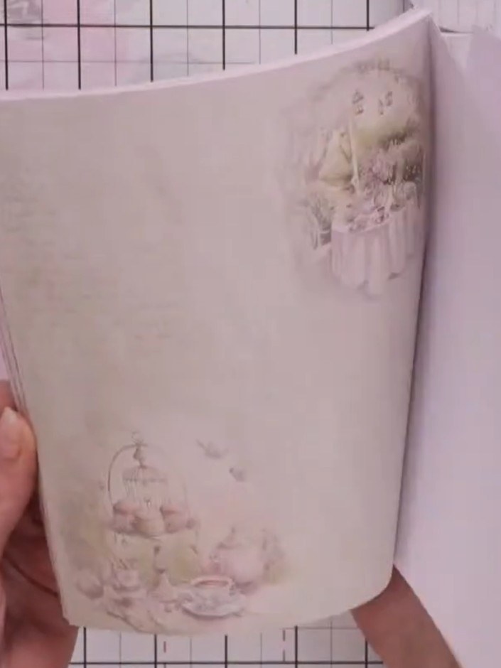 Step 2: Fold back the top corner of the vellum sheet to create a pocket effect, revealing the decorative floral paper 
