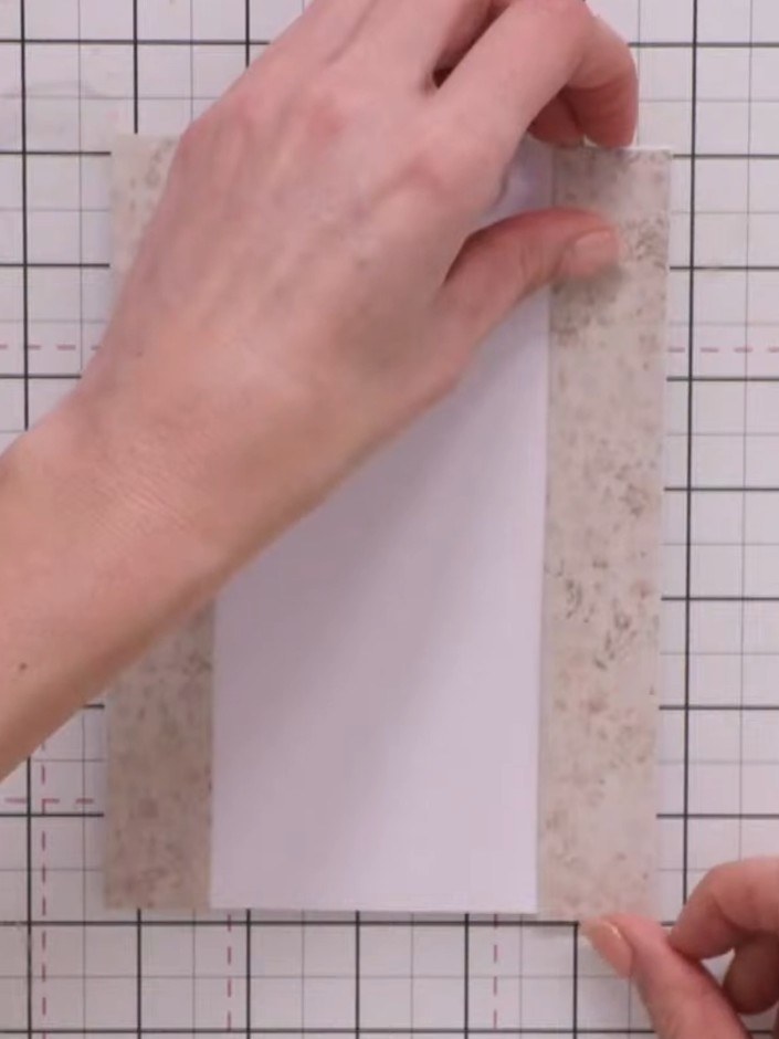 Step 2: Position the first decorative paper strip vertically down the left side of your white card base. Secure it at 
