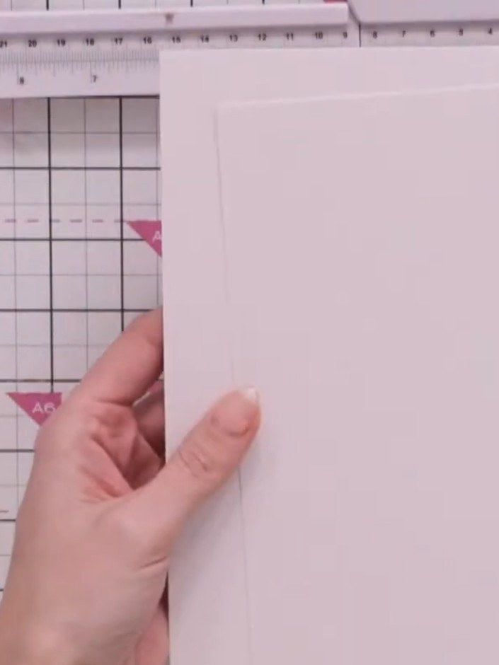 Step 5: Take one of the two pieces of card and trim approximately one millimetre off the long side only using your gui