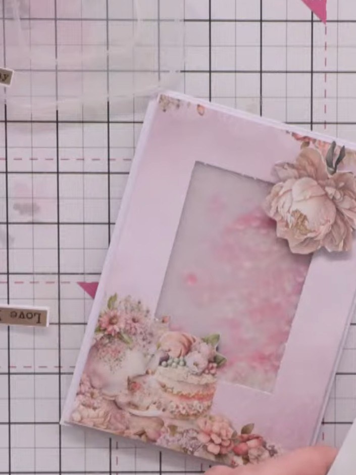 Step 12: Add a second flower with greenery to the bottom area of the frame to balance the design. Trim the greenery flu