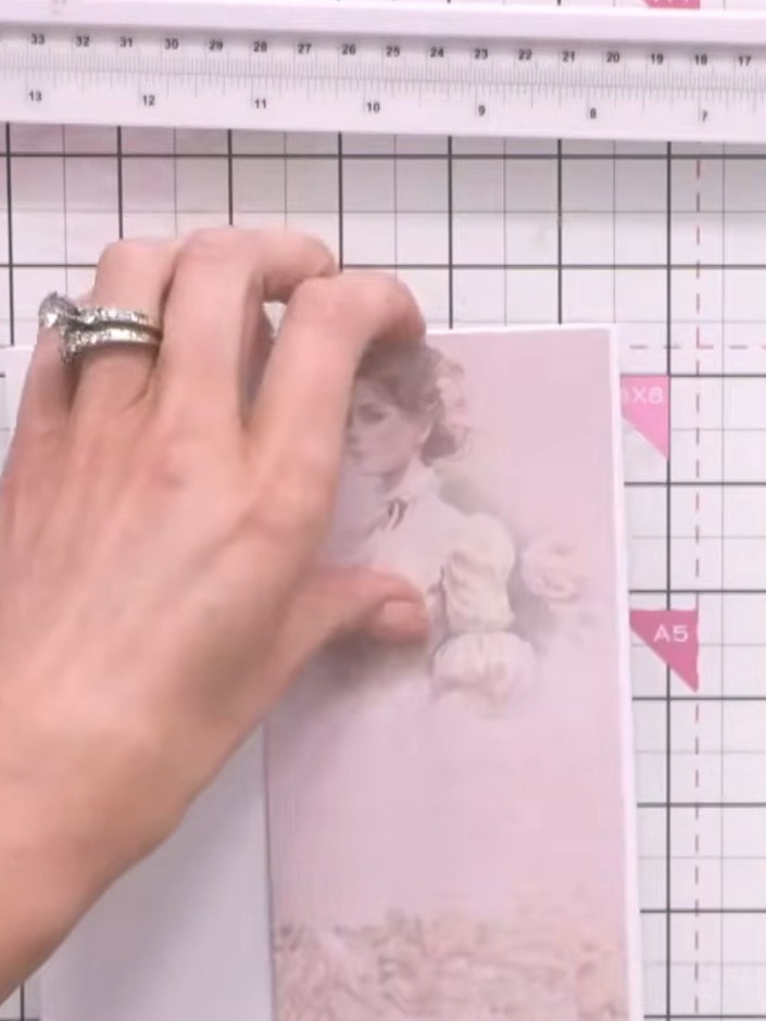 Step 8: Adhere a patterned paper strip featuring the vintage lady image down one side of the card base, positioning it