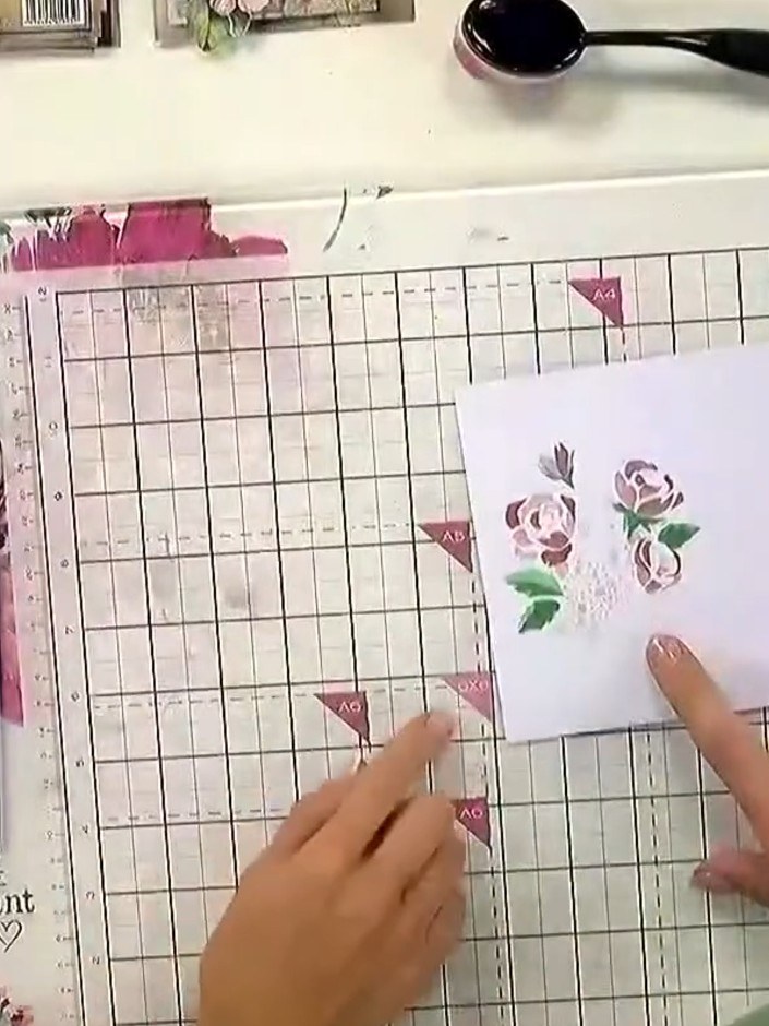 Step 7: Position your final layered stencil design on the card to complete the multi-coloured embossed effect. The lay