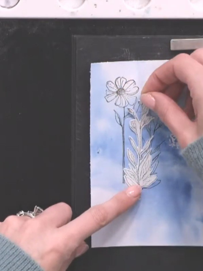 Step 5: Stamp additional flower heads at different angles across the watercolour background to create perspective and 