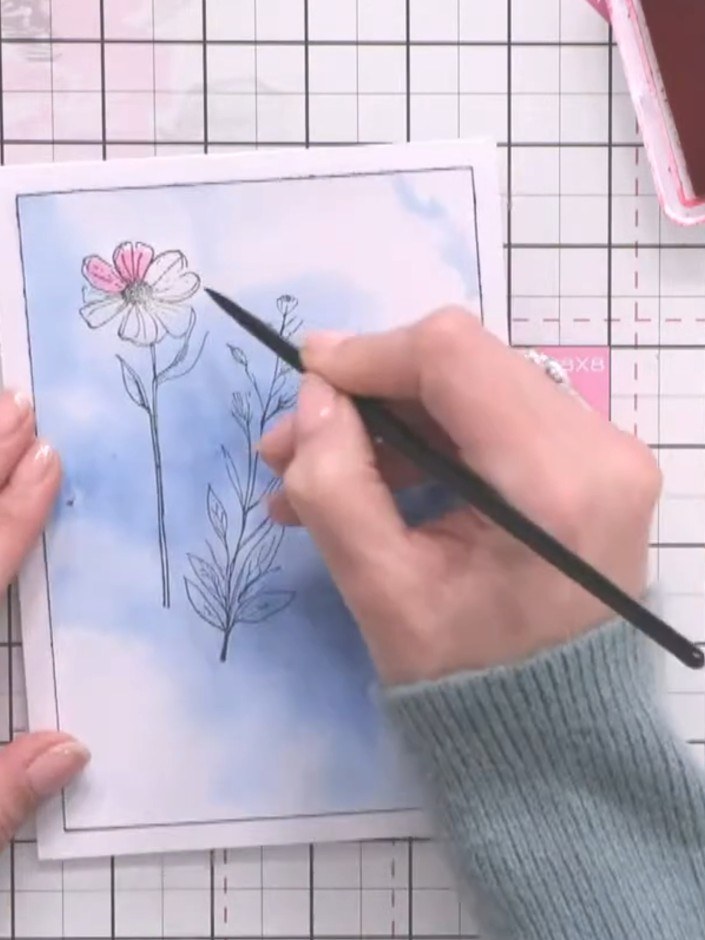 Step 6: Using a paintbrush, colour the flower heads with pink watercolour, adding touches of colour to the petals. Lea