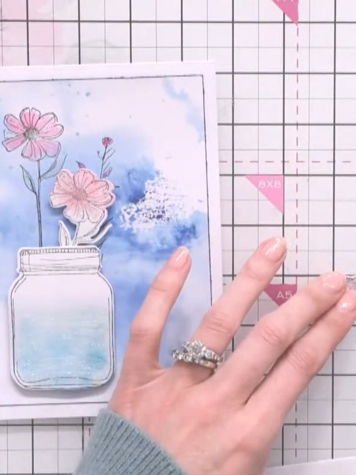 Step 8: Arrange the dimensional pink flowers onto the card front, positioning them in the jar. Adhere them in place us