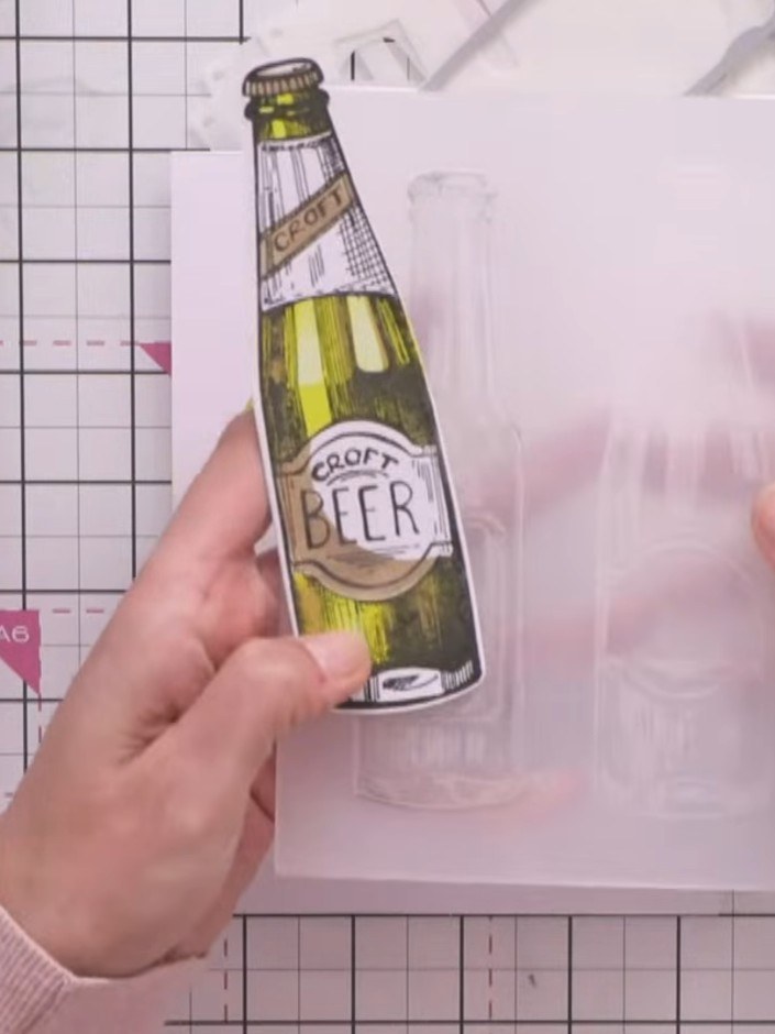 Step 4: Line up the die-cut beer bottle piece with the embossing folder, matching the ridges on the bottle cap to the 