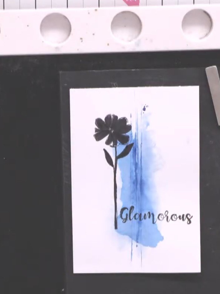 Step 4: Use a white gel pen to add highlights and details to the black silhouette flower and the blue watercolour back