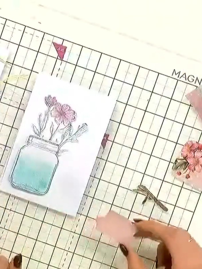 Step 7: Position the die-cut floral elements on top of the mason jar image to add dimension and detail to your card. A