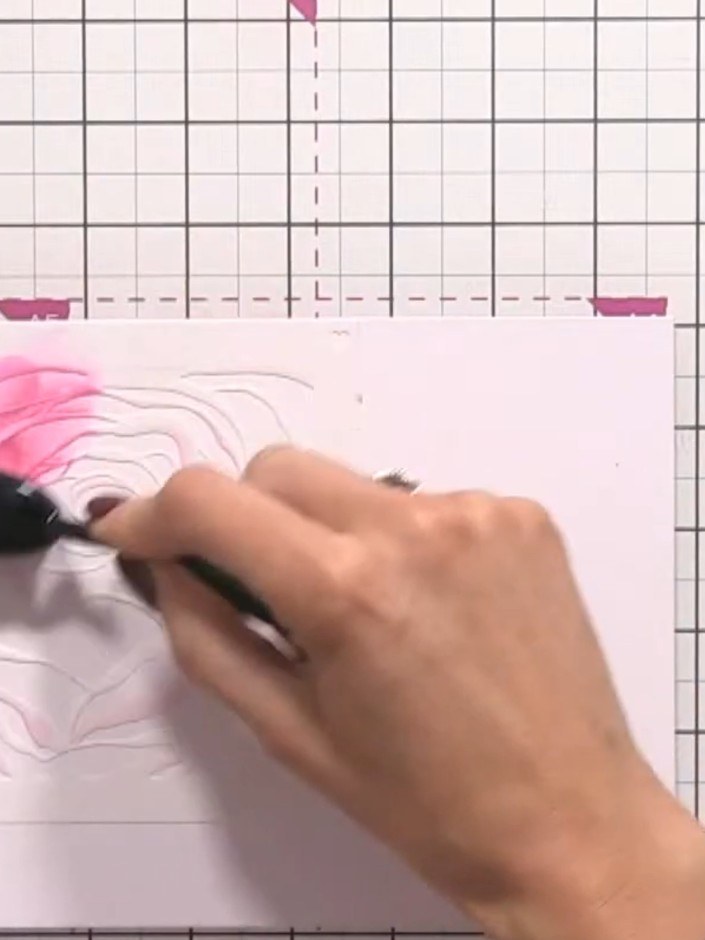 Step 3: Position stencil number two, aligning it with the edge of your card. Apply pink ink through the stencil using 