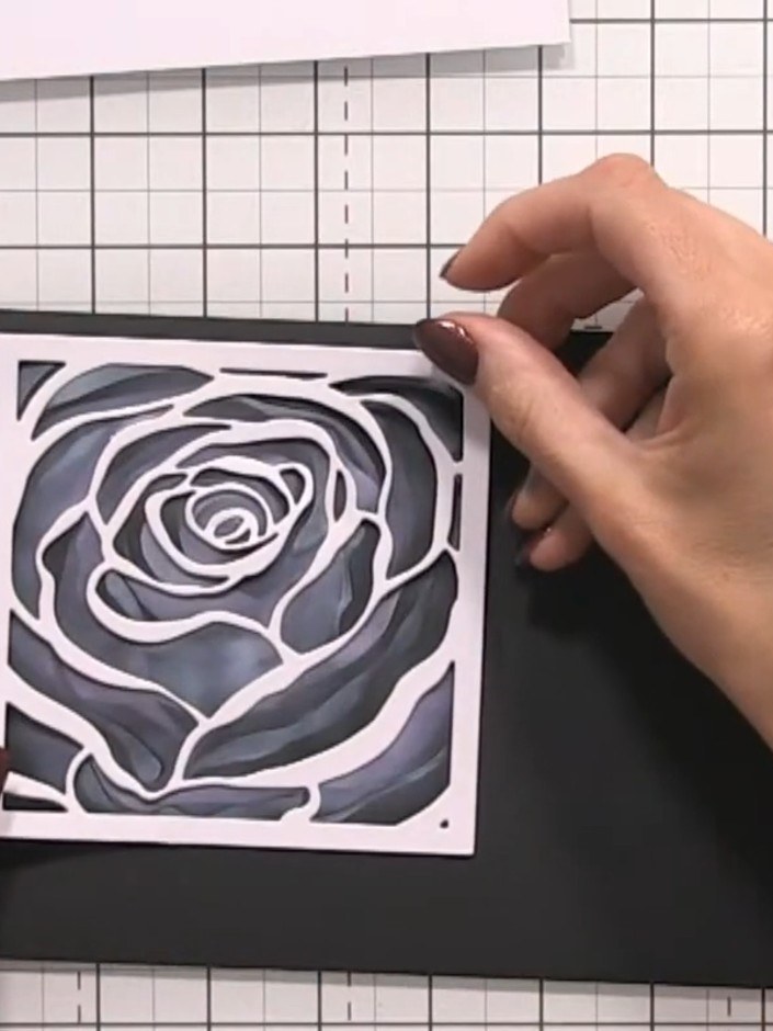 Step 6: Place the rose stencil back on top of the black card. Apply white ink through the stencil to create a white ha