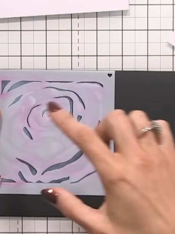Step 7: Place stencil number one over the white halo on the black card. Apply pink ink through the stencil using a ble