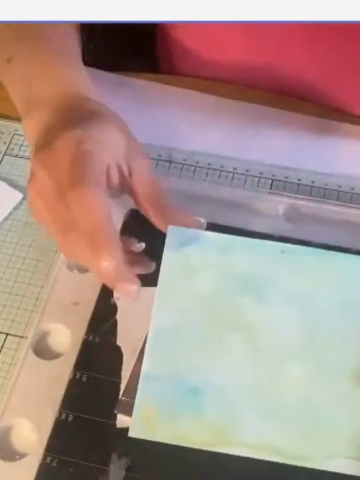 Step 1: Apply a light watercolour wash to white card stock using diluted paint and water, blending soft colours across