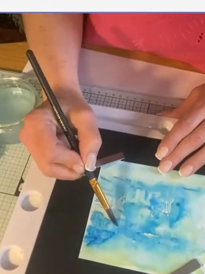 Step 5: Heat dry the blended blue and green background completely. Using the handle end of a stamp pad, dab metallic i