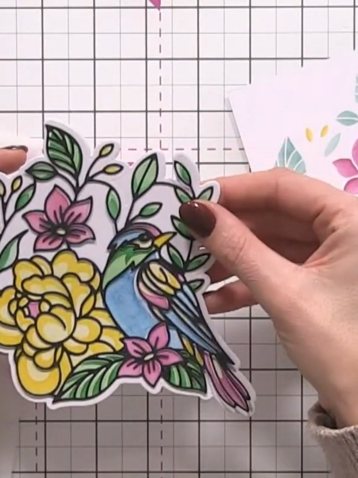 Step 5: Take the detailed floral overlay die-cut from black cardstock and position it over the coloured stamped image.