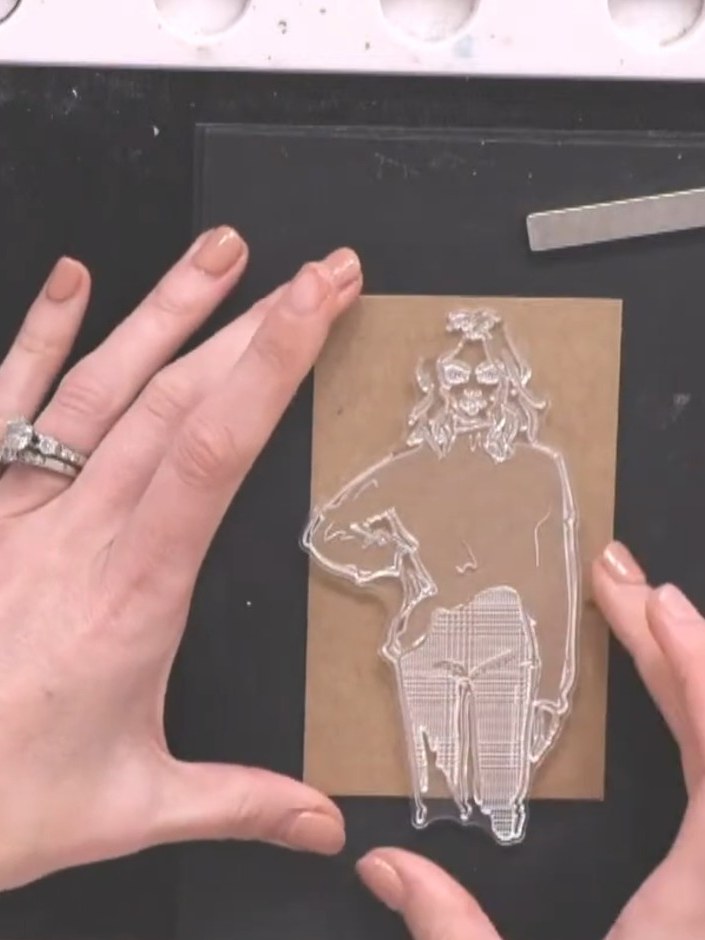 Step 2: Stamp one of the three girls from the Imala bundle onto each kraft card panel using black ink, positioning the
