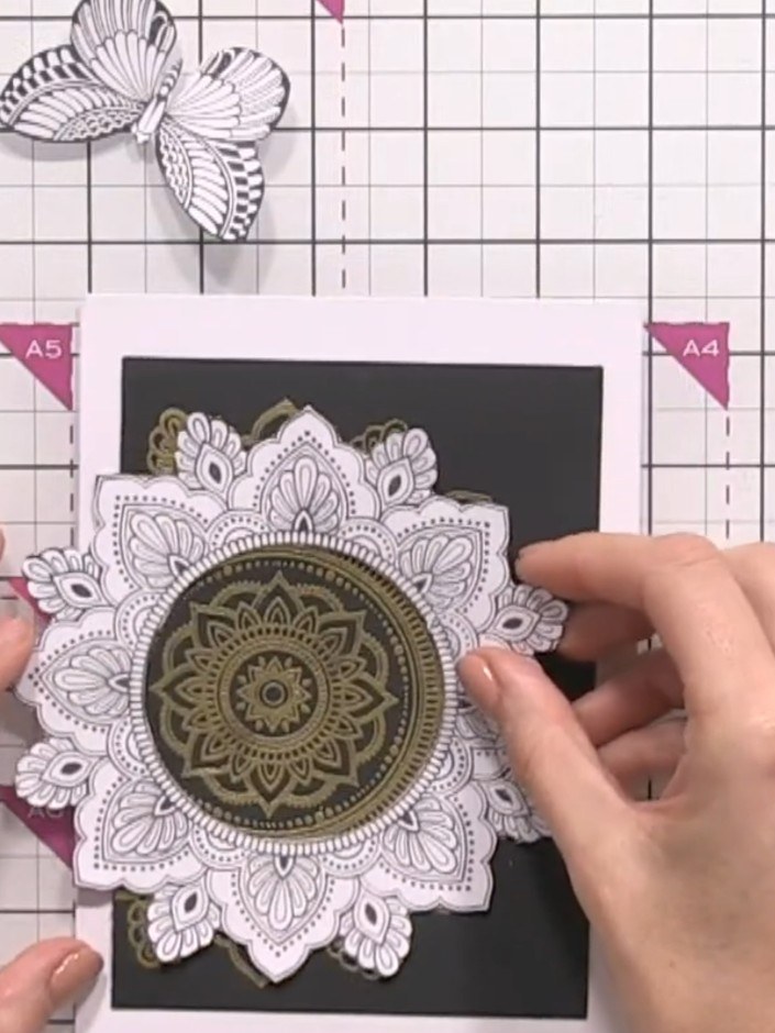Step 2: Heat-emboss the stamped mandala design with gold embossing powder using a heat tool. The gold embossing will a