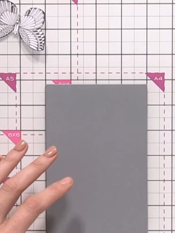 Step 4: Schneide einen grauen Kartenrohling in der Hälfte durch, damit du eine kleinere Kartenbasis bekommst. Position the floral panel on the grey card to che