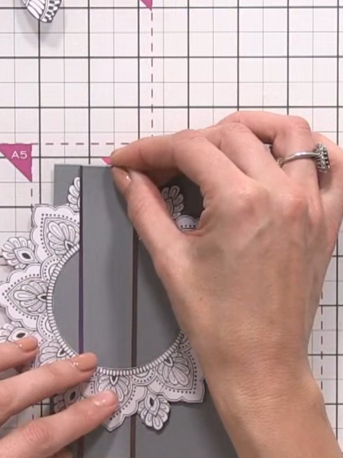 Step 6: Trim away the excess patterned paper panel so it sits flush with the grey card edges. Use scissors or a trimme