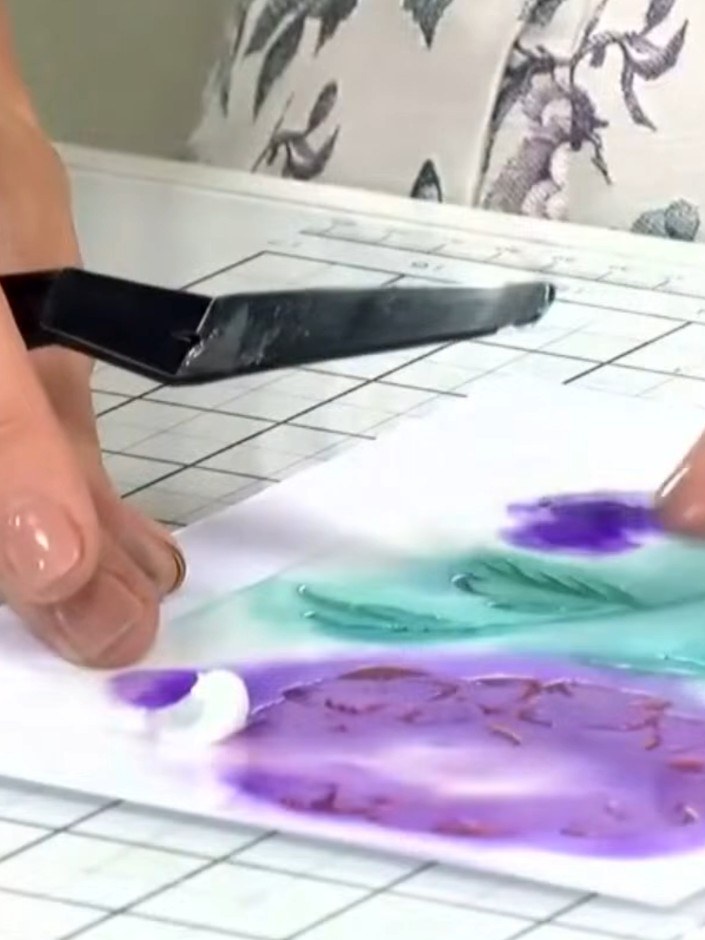 Step 3: Hold stencil number five in place on your card and push the glitter paste through using a spatula, working it 