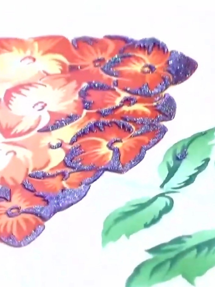 Step 6: Carefully peel away the stencil to reveal the coral and purple glittered flower design. Complete the card by d