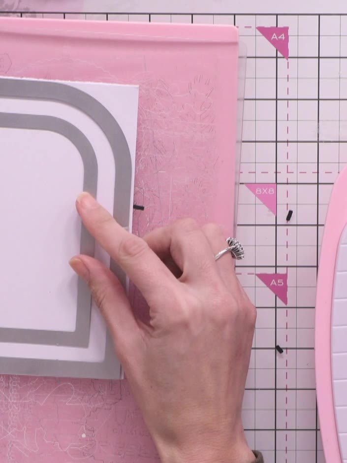 Step 4: Position the smaller rounded rectangle die inside the larger die on your white cardstock to create a nested fr