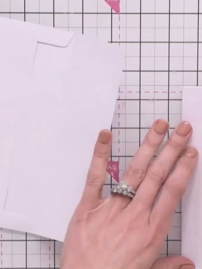 Step 2: Take a second white envelope and position it next to your first envelope on the craft mat. Secure the second e