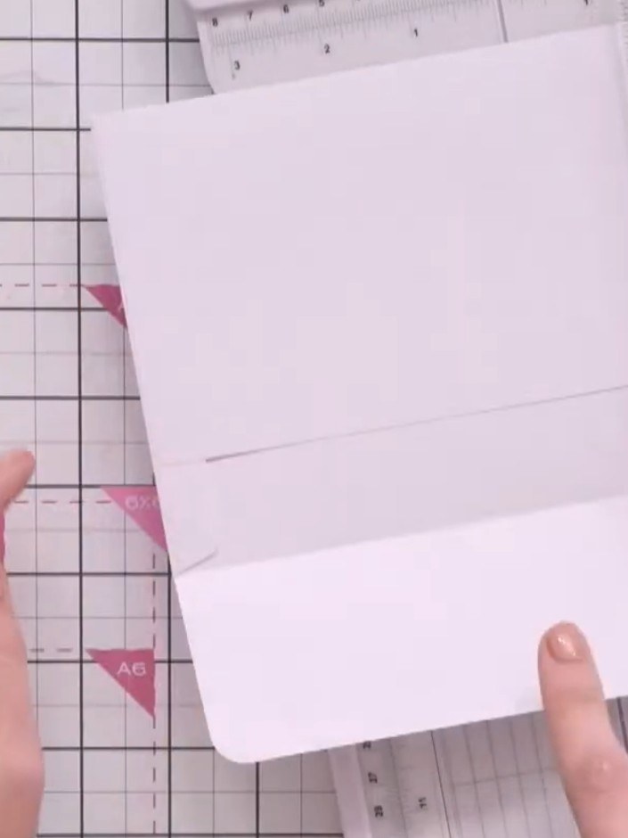 Step 3: Open an envelope's flap and position it on the guillotine. Cut from the centre of the envelope up to the score