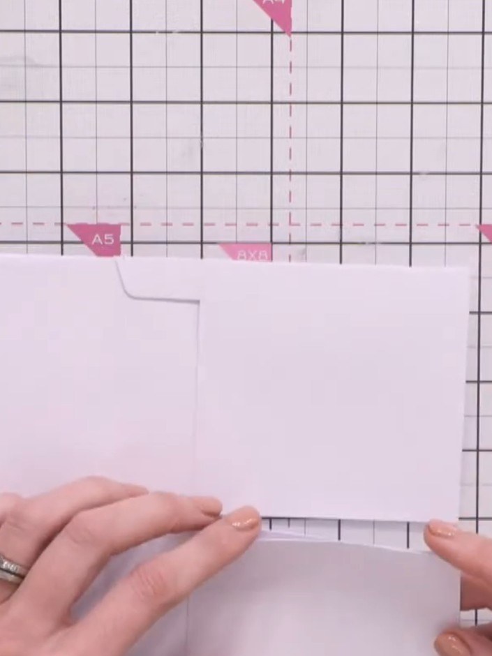 Step 6: Schneide mit dem Papierschneider einen schmalen Streifen vom Ende des Umschlags ab, damit eine offene Tasche entsteht.