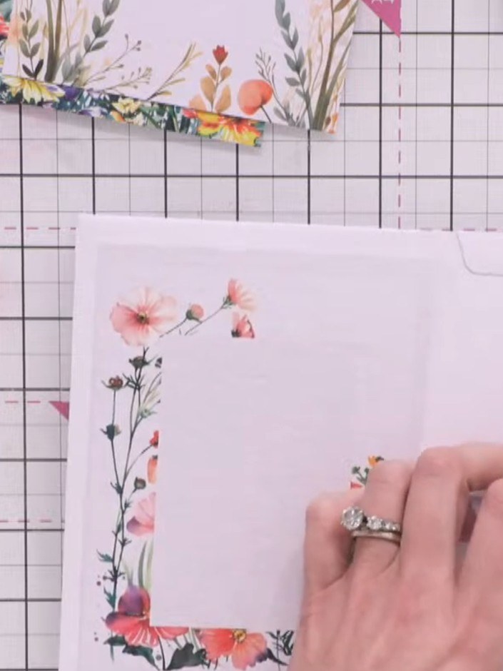 Step 9: Create a corner pocket by applying tape to one side and the bottom edge of a floral topper. Position the toppe
