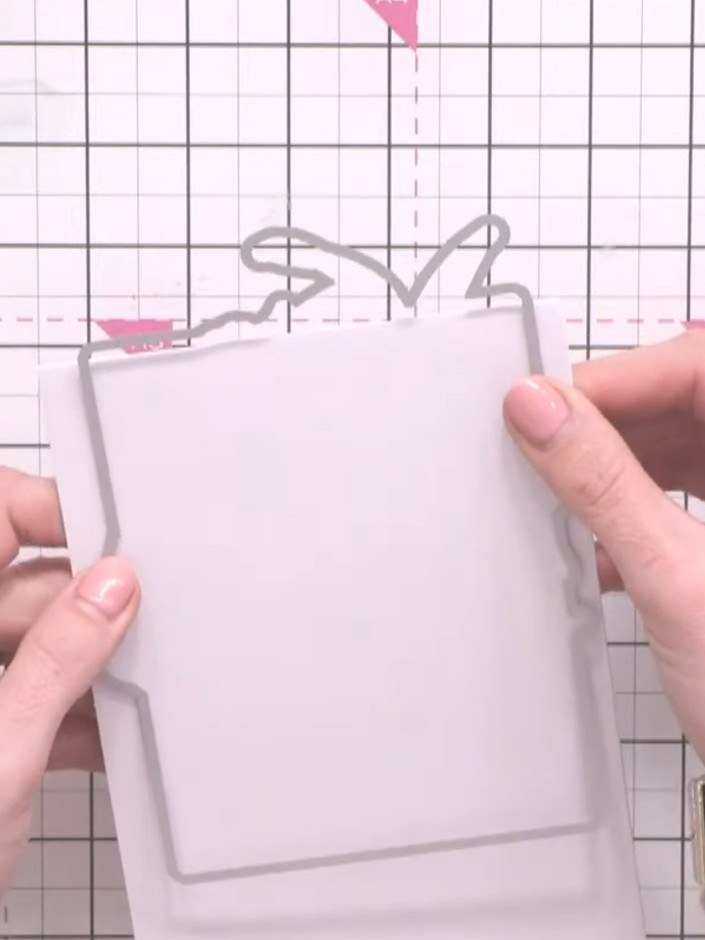 Step 11: Position the outline die across the top hinge of a folded white notecard so it cuts the shaped edge but leaves