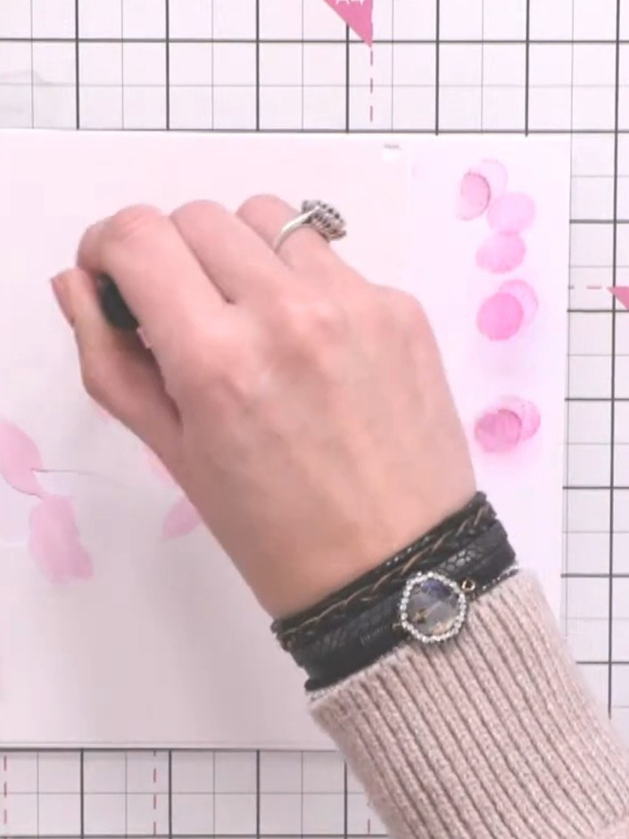 Step 8: Position stencil number three over the flower centre. Apply a darker shade of pink ink through the stencil to 