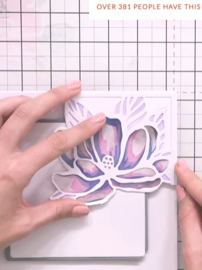 Step 11: Use the magnolia stencil to add light touches of teal ink to any white spaces on the card front to balance the