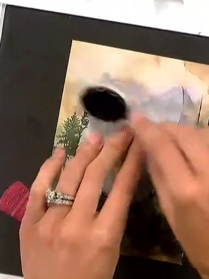 Step 5: Carefully peel away the mask stencil from the black card to reveal the white halo effect around the stamped wo