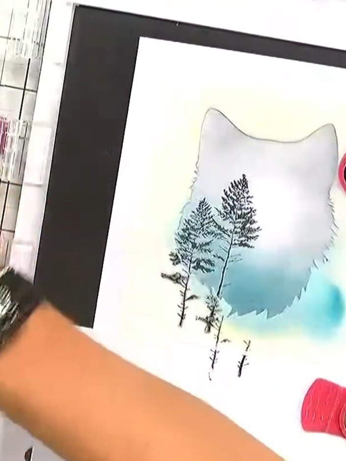 Step 4: Position the tall tree stamp at the bottom of the fox silhouette, using only the lower portion of the stamp. I