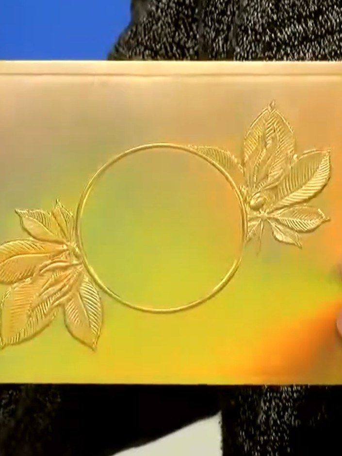 Step 5: Open the embossing folder carefully to reveal the raised, embossed design on your card. The metallic card will