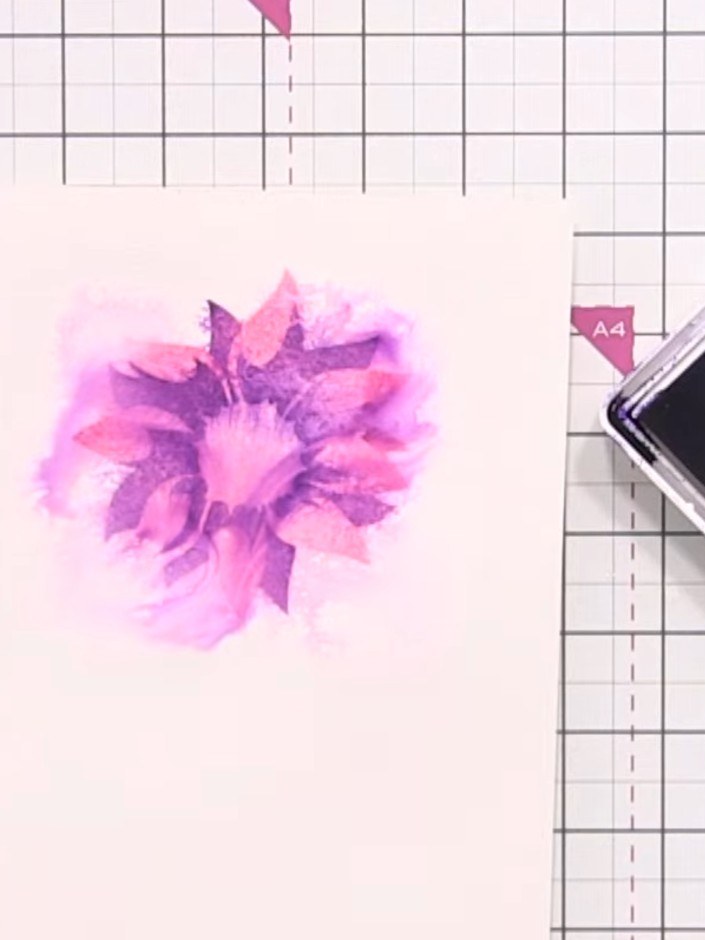 Step 7: Lightly spray the stencilled flower with water to allow the purple and pink inks to disperse and blend. Dry th