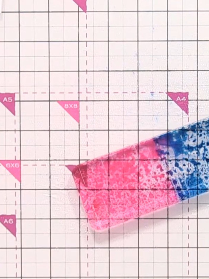 Step 4: Spray the inked acrylic block with water from a spray bottle to activate the pink and blue inks and create a b