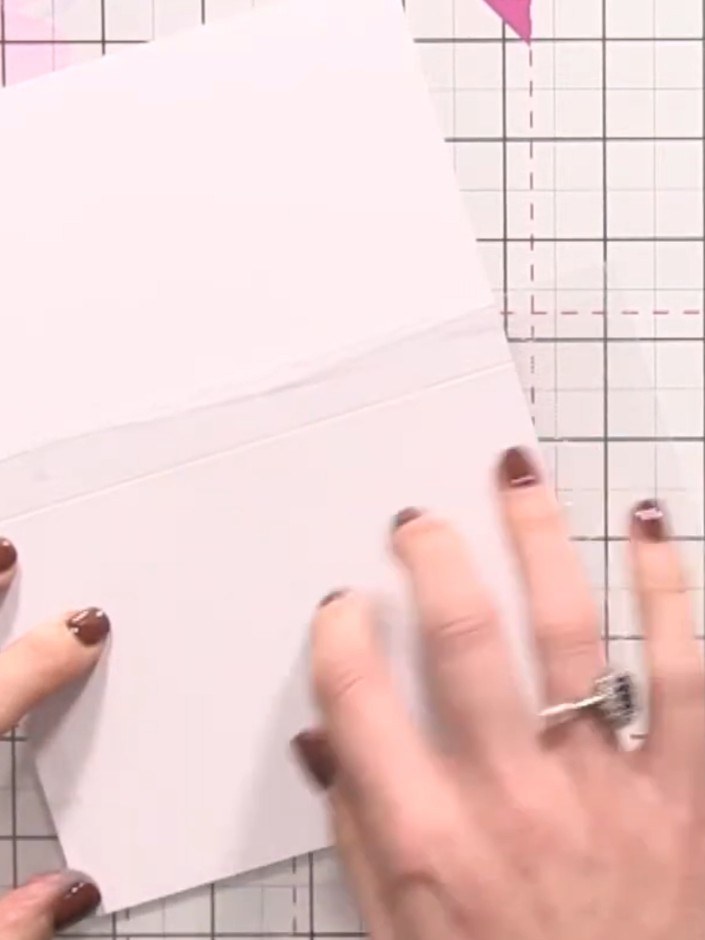Step 3: Tap and press the cellophane bag across the white card to transfer the sticky ink unevenly, creating a texture