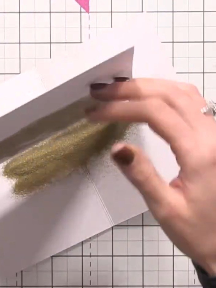 Step 5: Sprinkle gold embossing powder over the sticky ink areas on the white card. Tap off the excess powder and heat