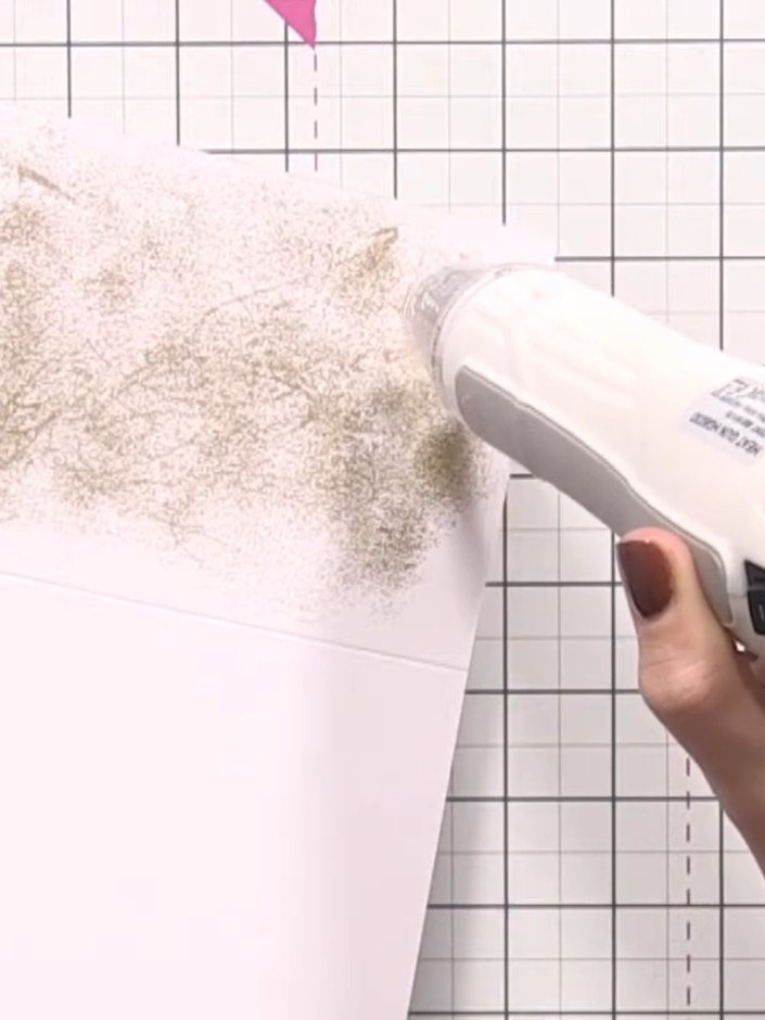 Step 7: Use a heat gun to melt and set the embossing powder, moving it steadily over the surface. The powder will tran