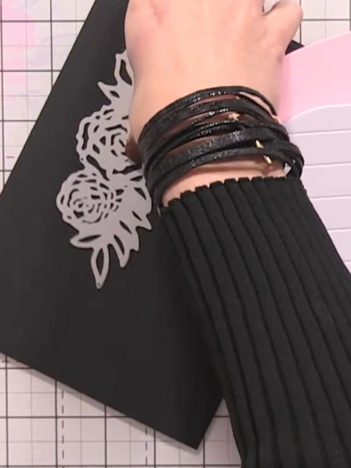 Step 8: Place the black cardstock with the rose die on top onto the cutting platform. Run it through your die-cutting 